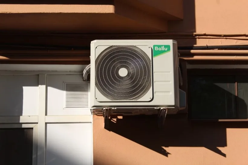 Technician repairing an outdoor air conditioner unit